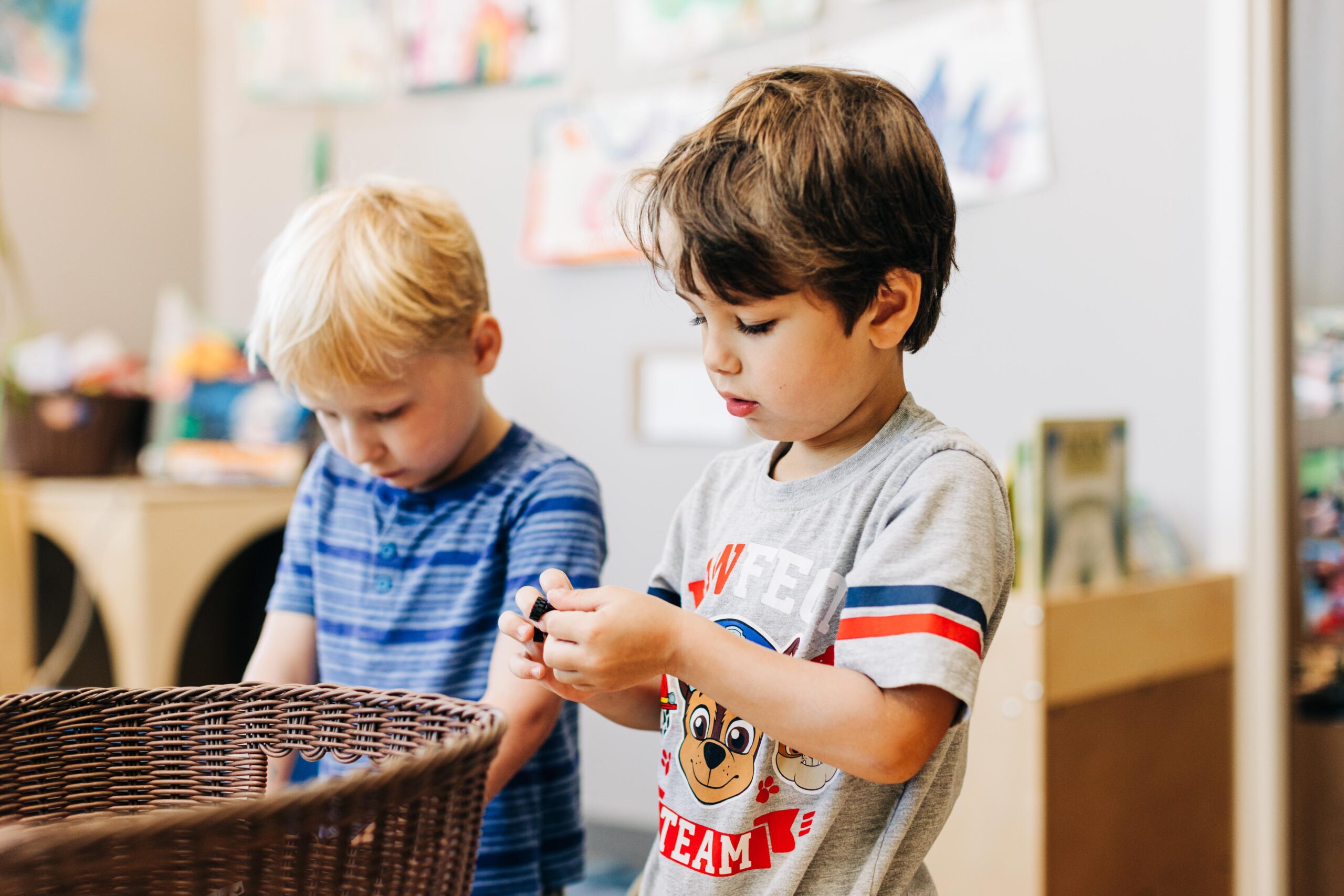 Two preschooler boys playing with toys in a classroom