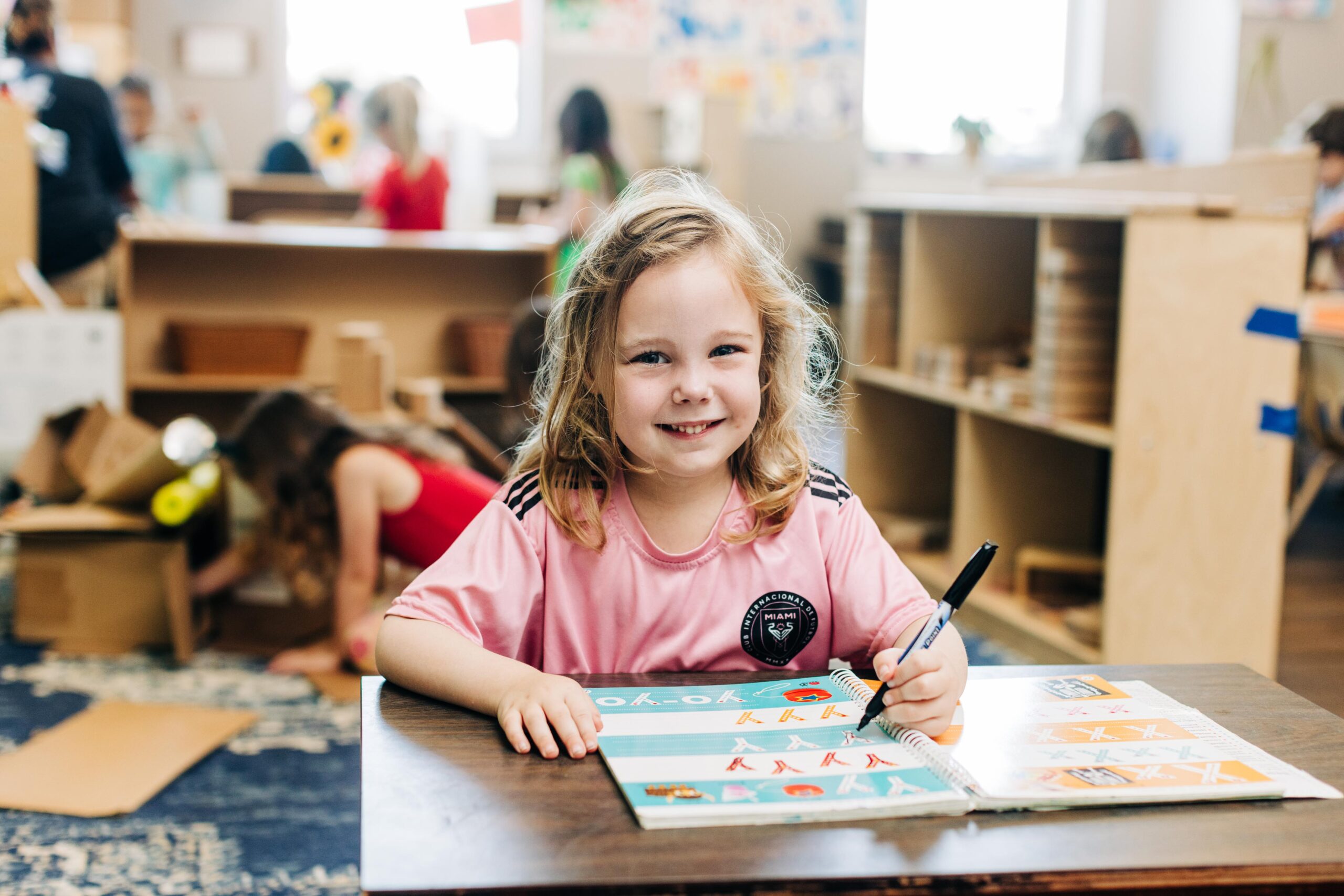 Preschooler working on a workbook in a classroom