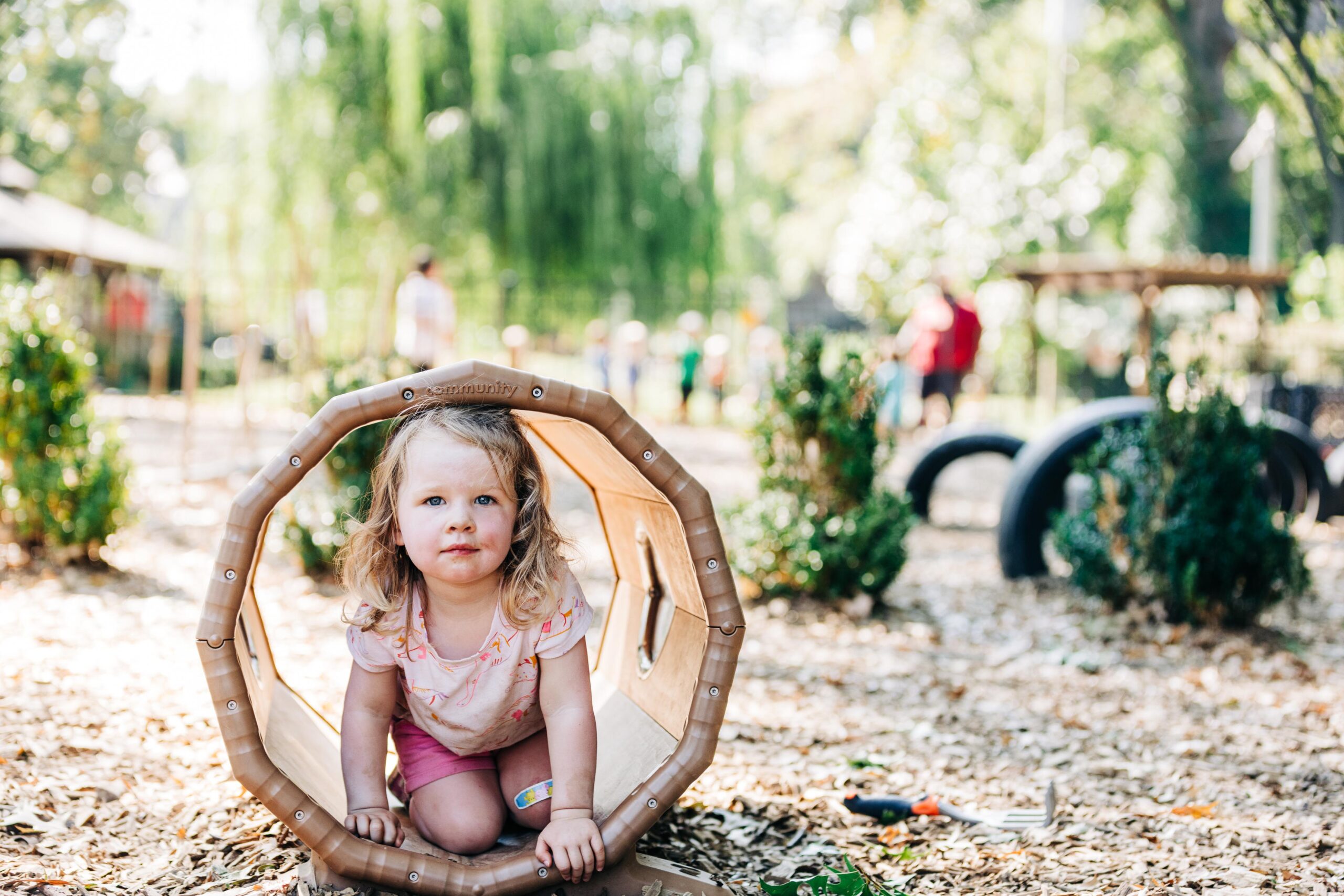 Young preschooler in tube on a natural playground