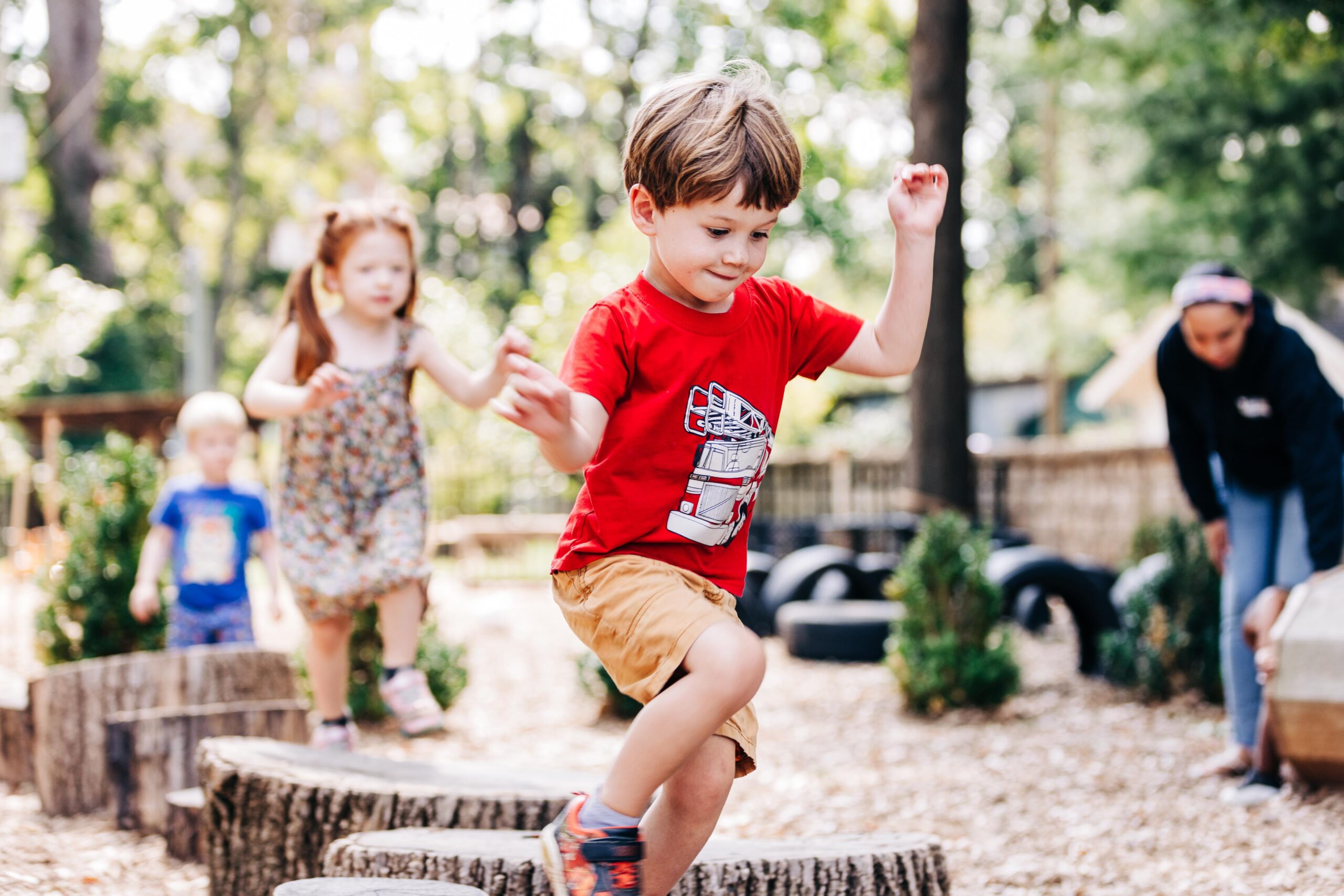 Young boy playing on tree stumps