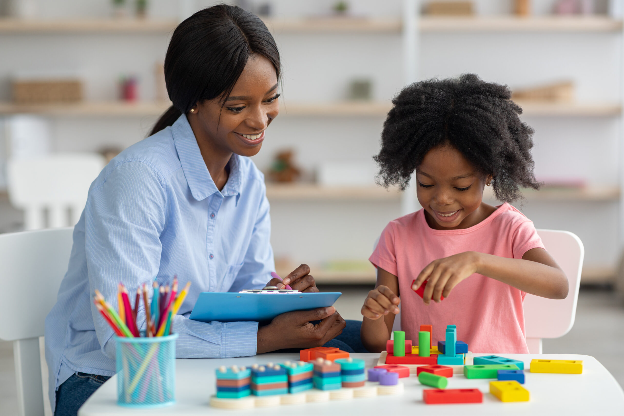 Female psychotherapist working with little kid at office