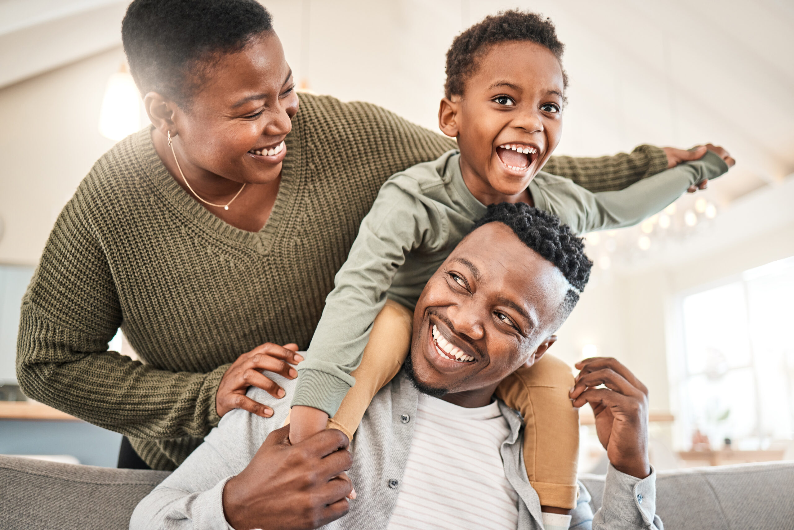 Shot of a happy young family playing together on the sofa at home.