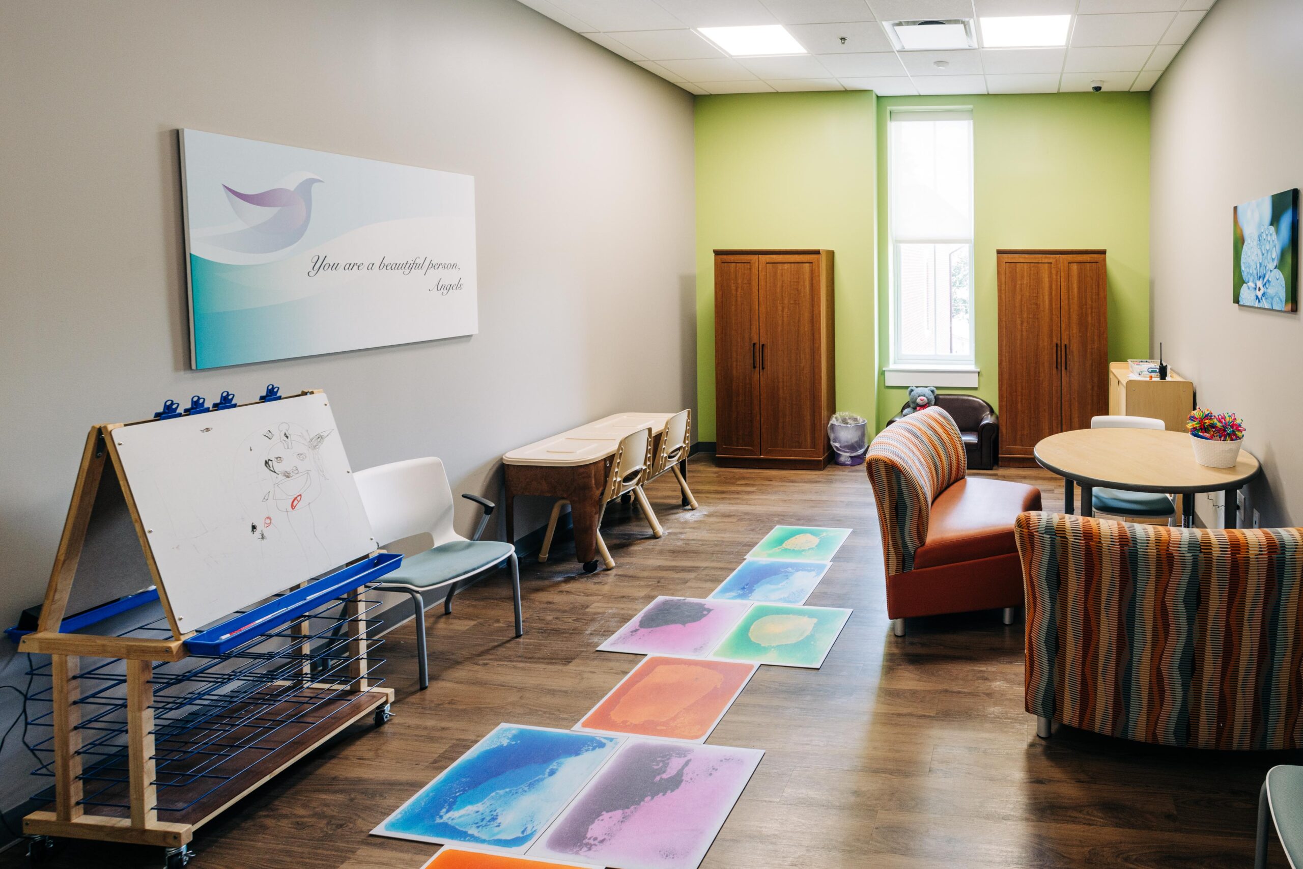 Therapy room with a table and chairs and areas for children.