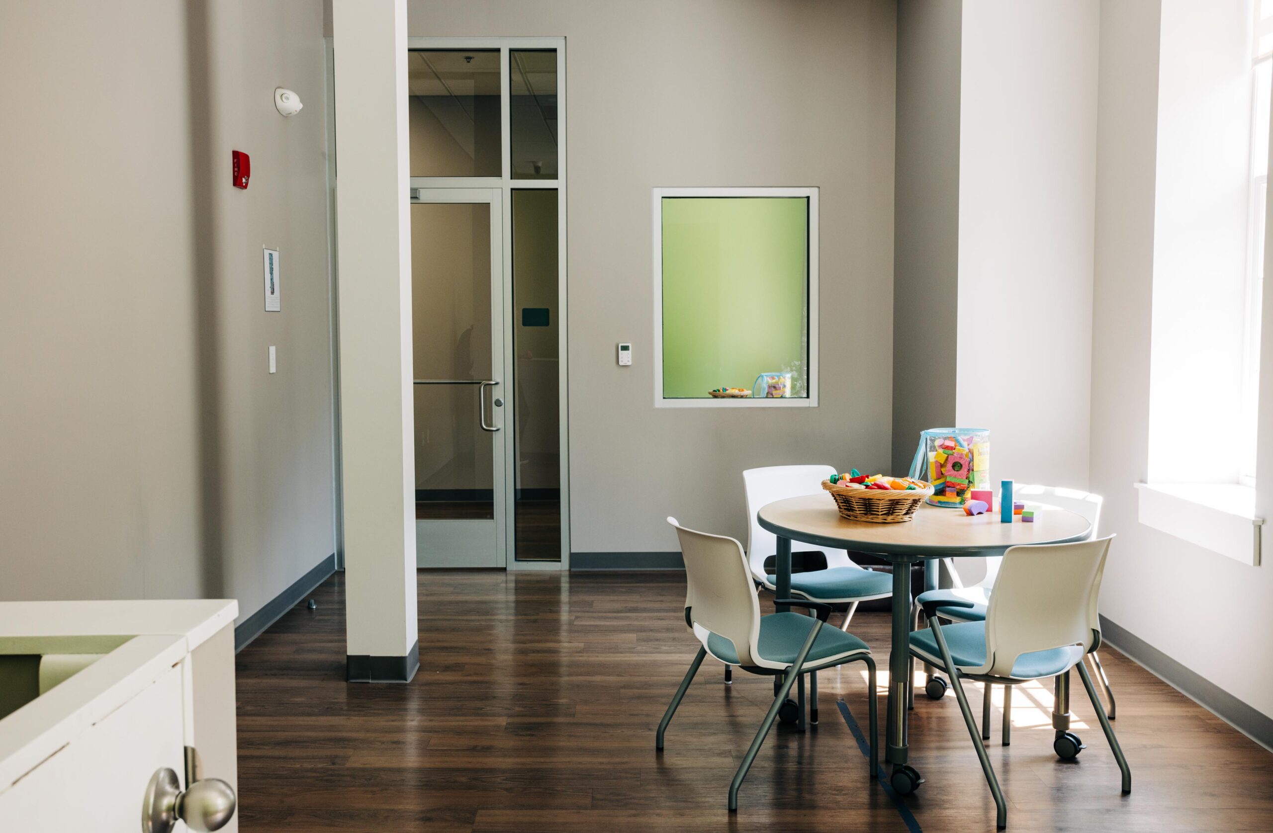 Therapy room with a table and chairs and toys for children.