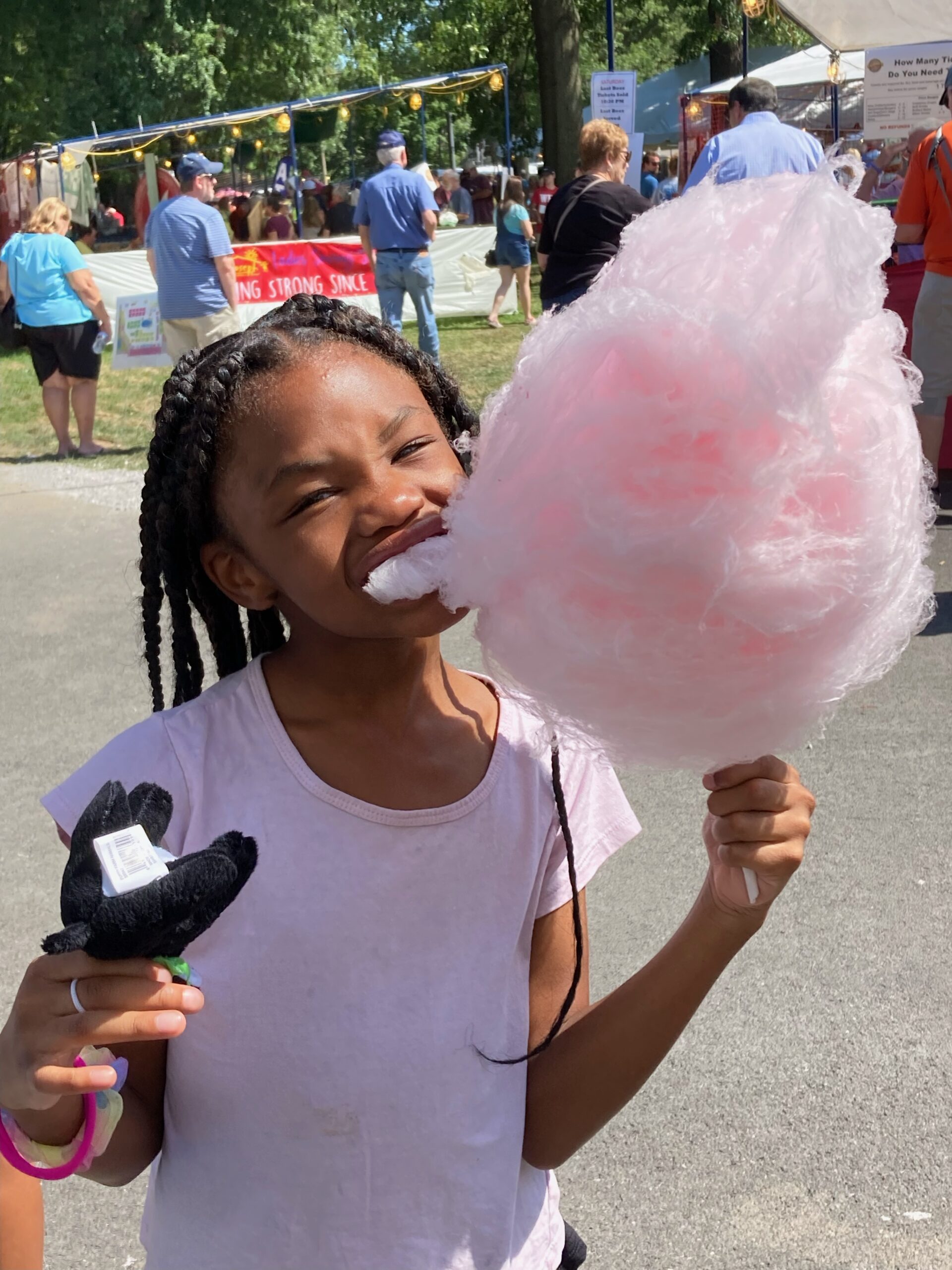 A child eating a pink cotton candy