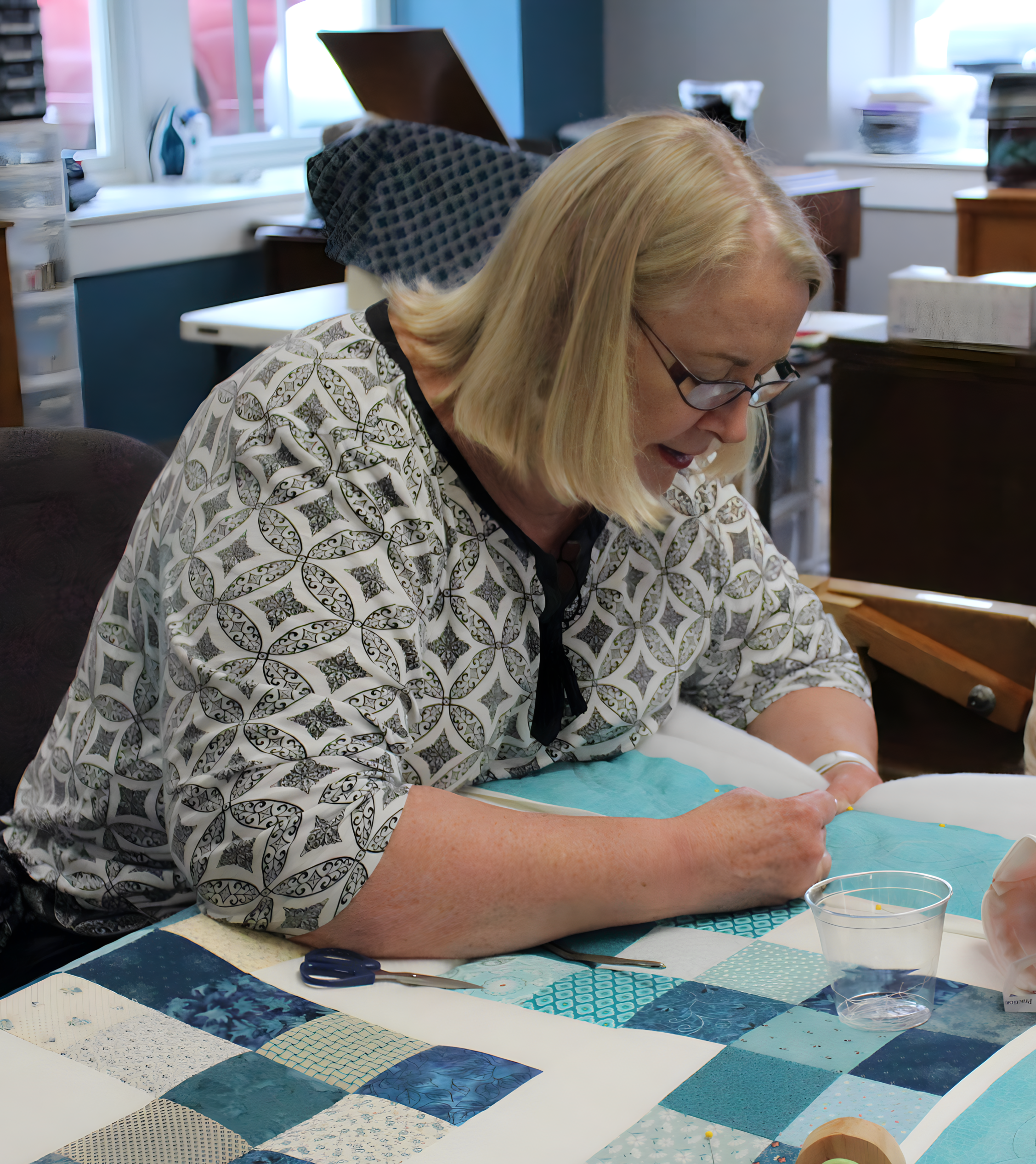 a woman sewing a quilt